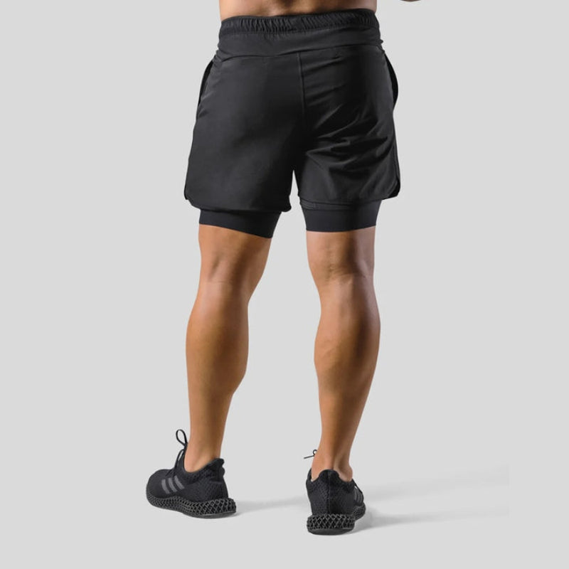 "2-in-1 sportbroek voor heren, blauw, met shorts en geïntegreerde zwarte compressielegging voor comfort en ondersteuning."