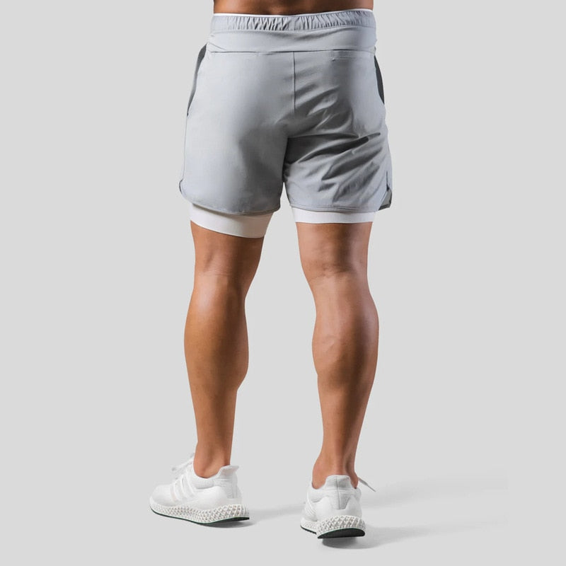"2-in-1 sportbroek voor heren, blauw, met shorts en geïntegreerde zwarte compressielegging voor comfort en ondersteuning."