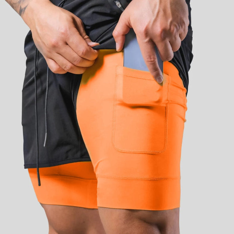 "2-in-1 sportbroek voor heren, blauw, met shorts en geïntegreerde zwarte compressielegging voor comfort en ondersteuning."