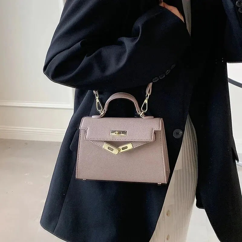 "Elegante dames schoudertas van leer, verkrijgbaar in beige, bruin, wit, en zwart, klassieke en stijlvolle uitstraling."