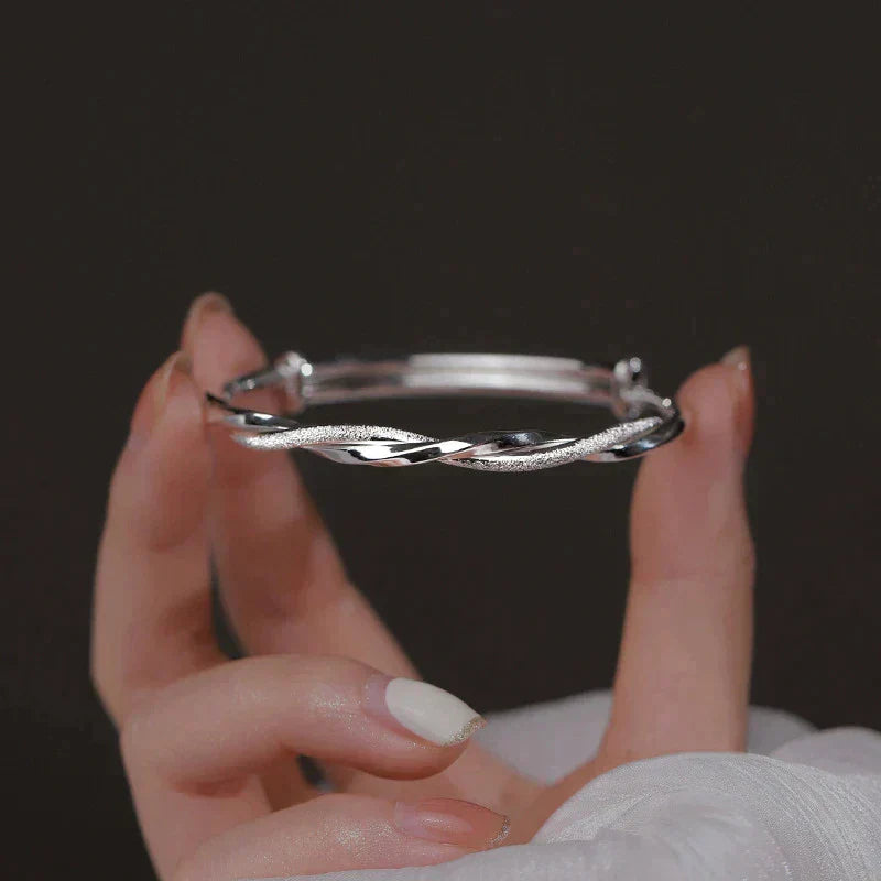 "Elegante gedraaide zilveren armband voor dames, verstelbaar, met glanzende afwerking en modern ontwerp"