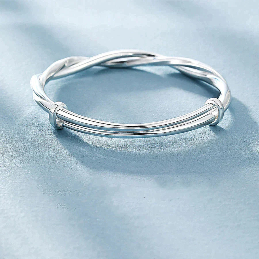 "Elegante gedraaide zilveren armband voor dames, verstelbaar, met glanzende afwerking en modern ontwerp"