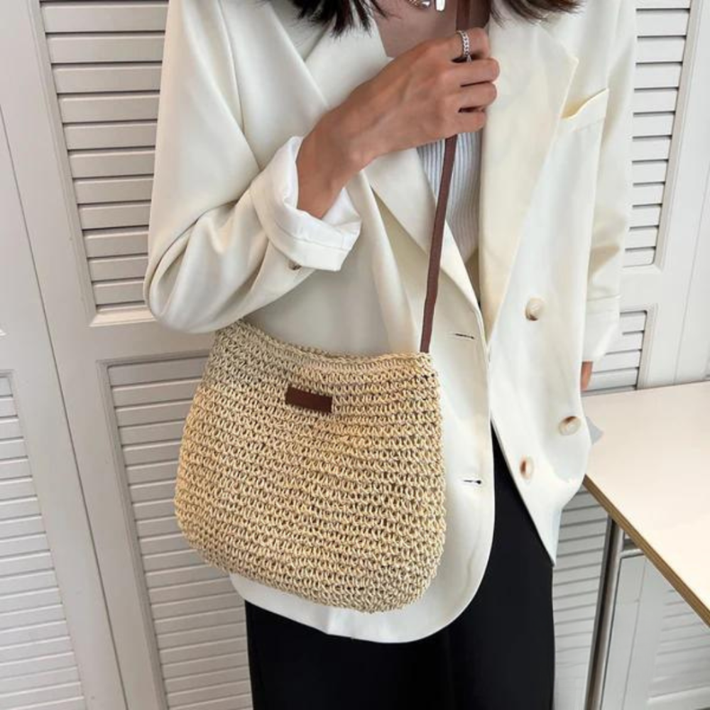 "Elegante gevlochten crossbody tas in beige en bruin met verstelbare band, ideaal voor casual of semi-formele gelegenheden."