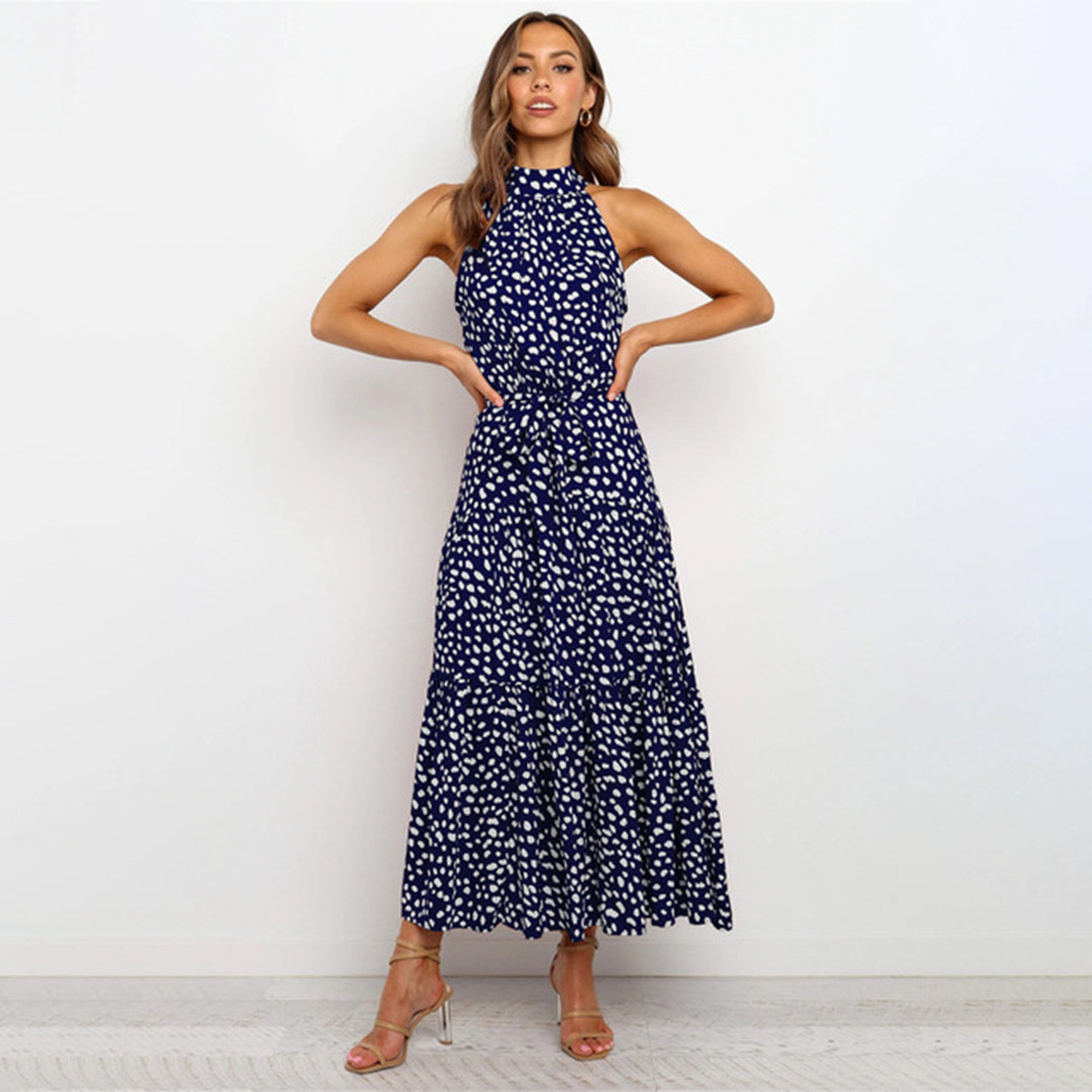 "Elegante lange jurk met stippen in vloeiende stof, verkrijgbaar in levendige kleuren zoals geel en marineblauw."