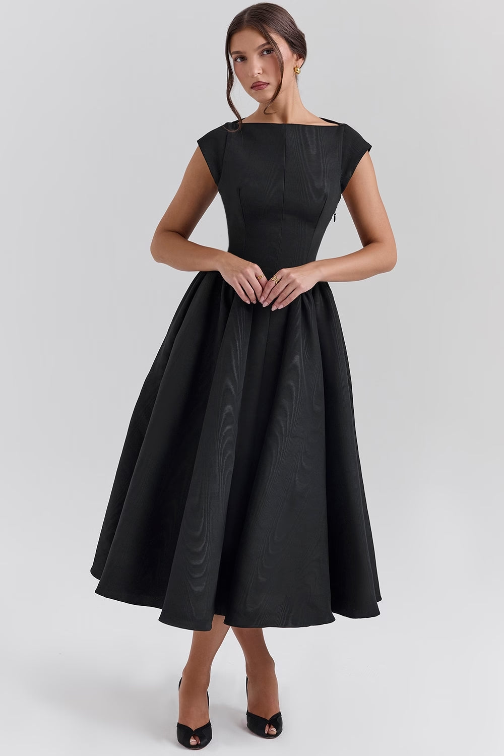 Elegante zwart-witte avondjurk met vloeiende rok en klassieke snit voor speciale gelegenheden. Stijlvolle dameskleding.