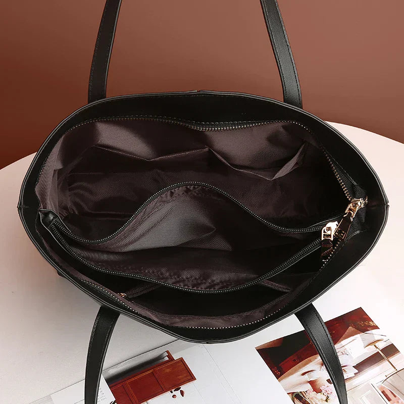 "Elegante, zwarte leren schoudertas voor dames met verstelbare riem en ruim interieur, ideaal voor elke gelegenheid."