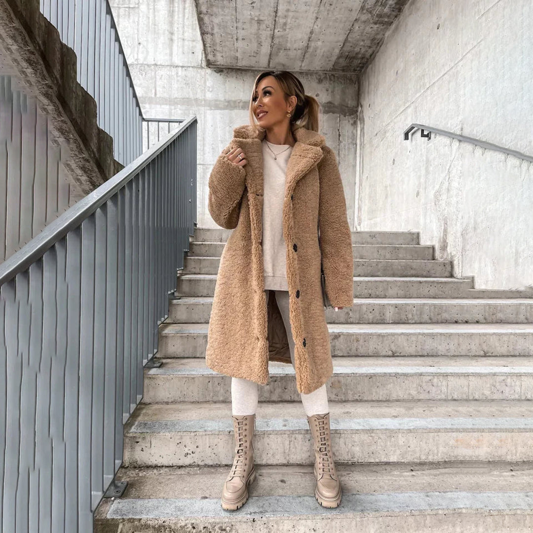 "Lange teddy jas dames, elegant beige, luxe winter mode, zachte stof, geschikt voor zowel formele als casual gelegenheden."
