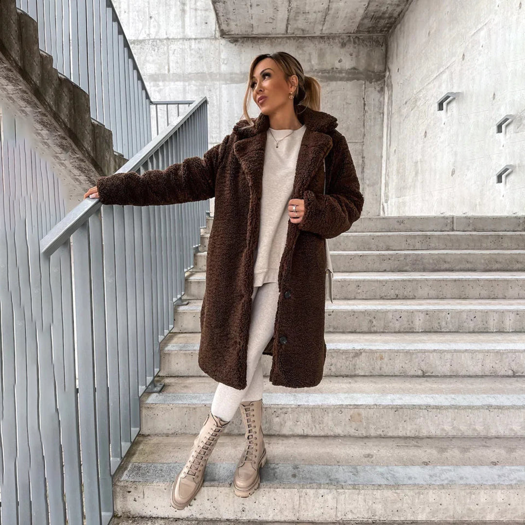 "Lange teddy jas dames, elegant beige, luxe winter mode, zachte stof, geschikt voor zowel formele als casual gelegenheden."