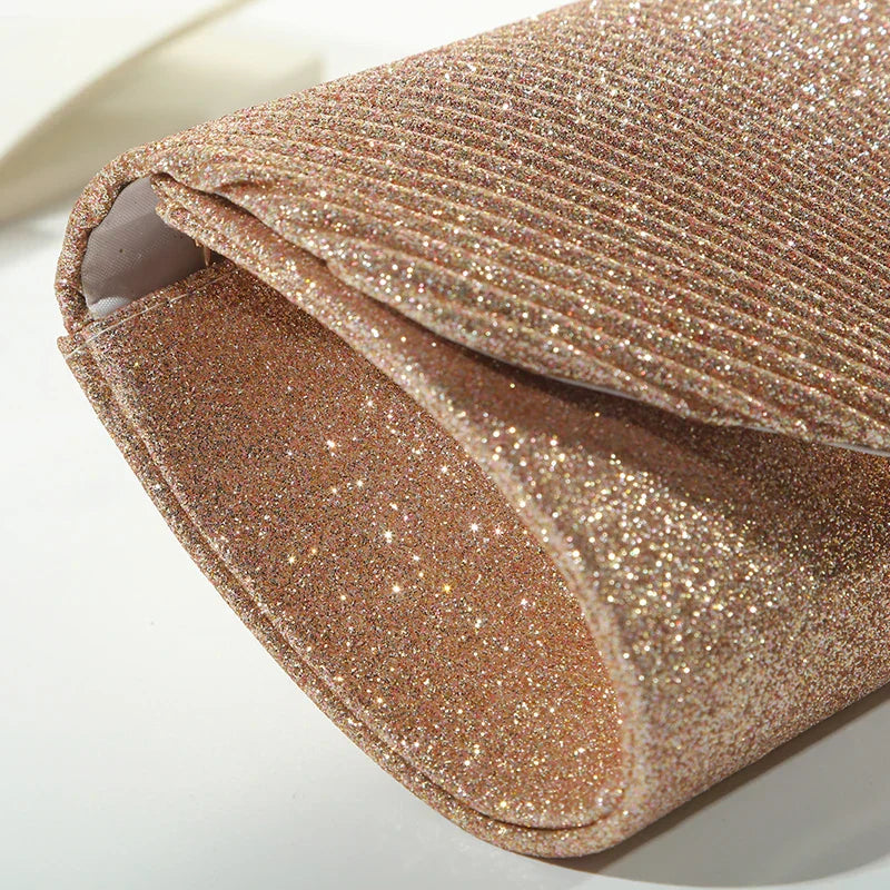 "Luxe gouden clutch met glitters, elegante sluiting en verwijderbare band, perfect voor avondgelegenheden."