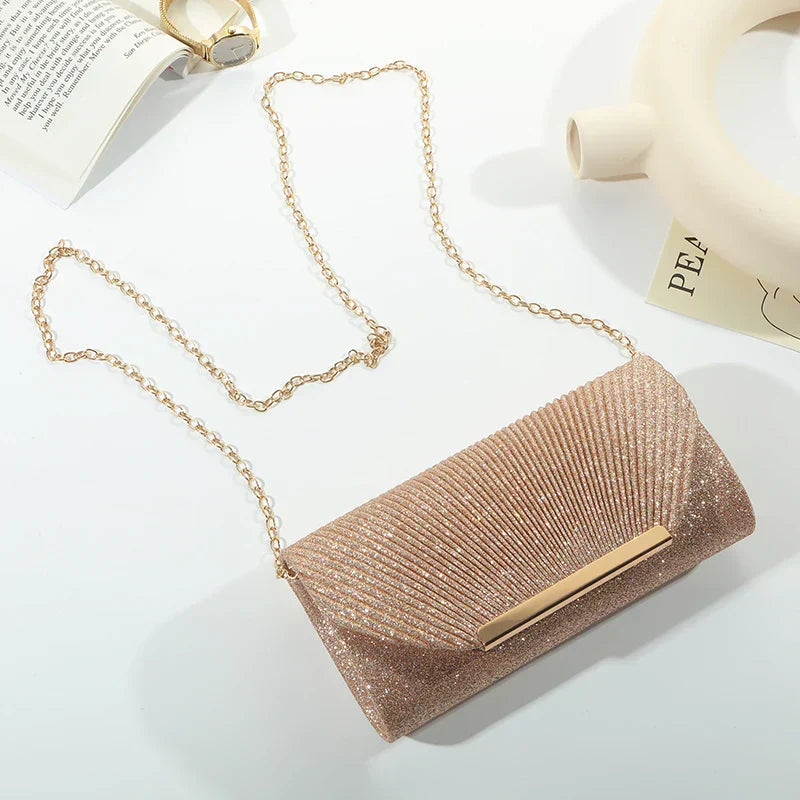 "Luxe gouden clutch met glitters, elegante sluiting en verwijderbare band, perfect voor avondgelegenheden."