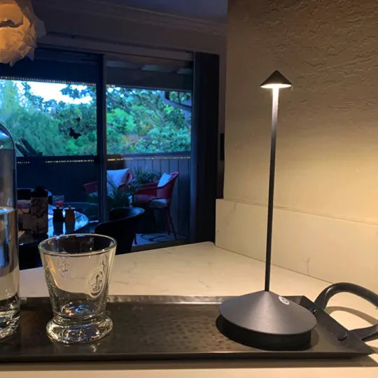 "Moderne draadloze LED tafellamp, dimbaar, waterbestendig, mat zwarte afwerking, voor binnen en buiten gebruik."