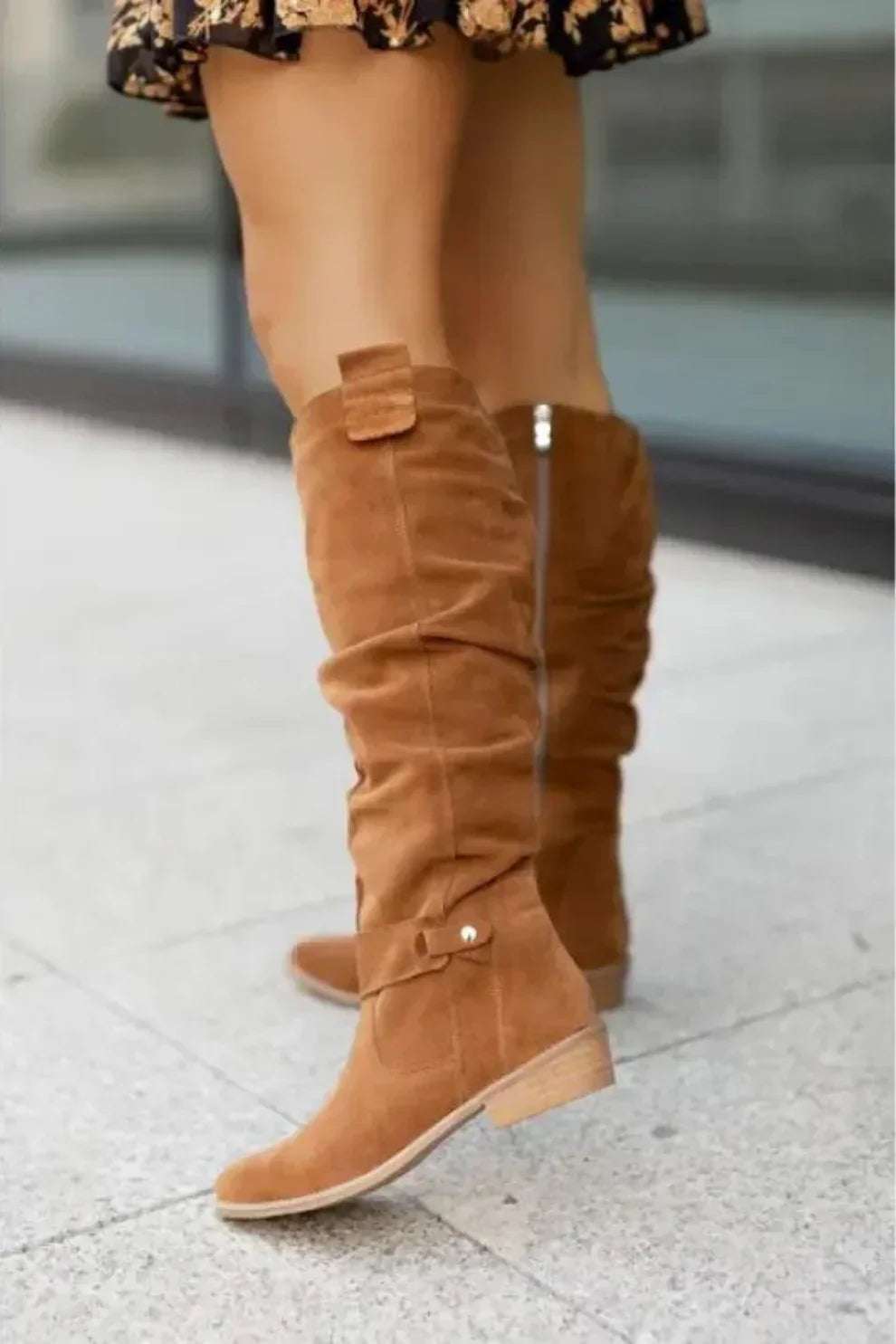 "Nora suède knielaarzen in bruin, elegant design met strikdetail en praktische rits, ideaal voor herfst en winter."