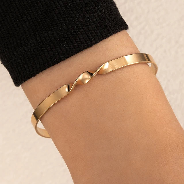 "Stijlvolle goudkleurige armband met kruissymbool, verstelbaar ontwerp voor dames, ideaal als mix & match sieraad."
