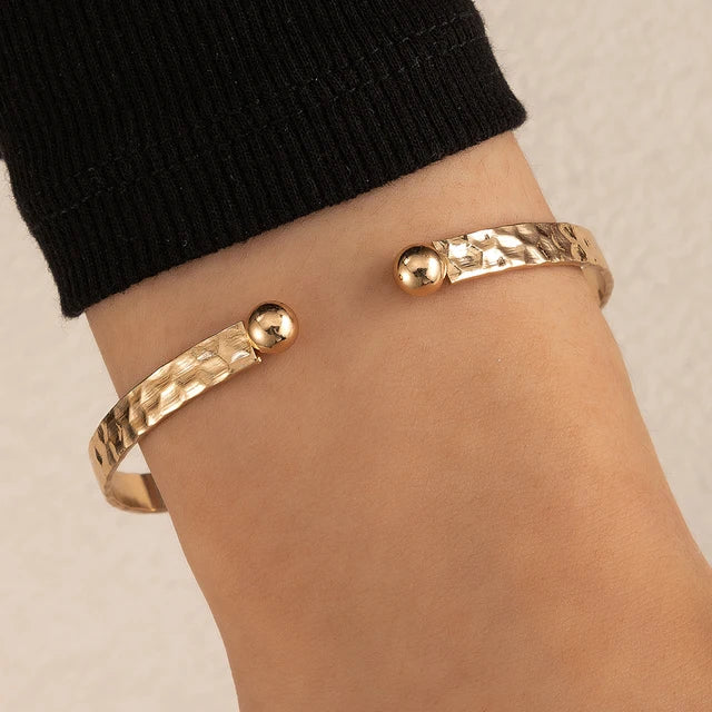 "Stijlvolle goudkleurige armband met kruissymbool, verstelbaar ontwerp voor dames, ideaal als mix & match sieraad."