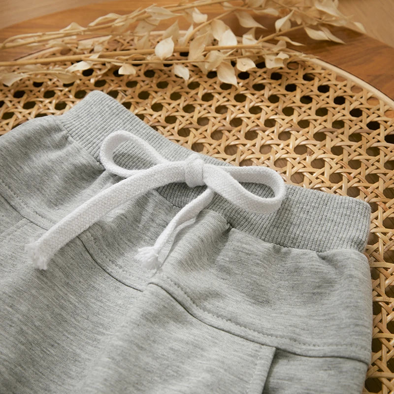 "Stoere herfstoutfit voor jongens met een kleurrijke letterprint trui en comfortabele broek, perfect voor actieve peuters."