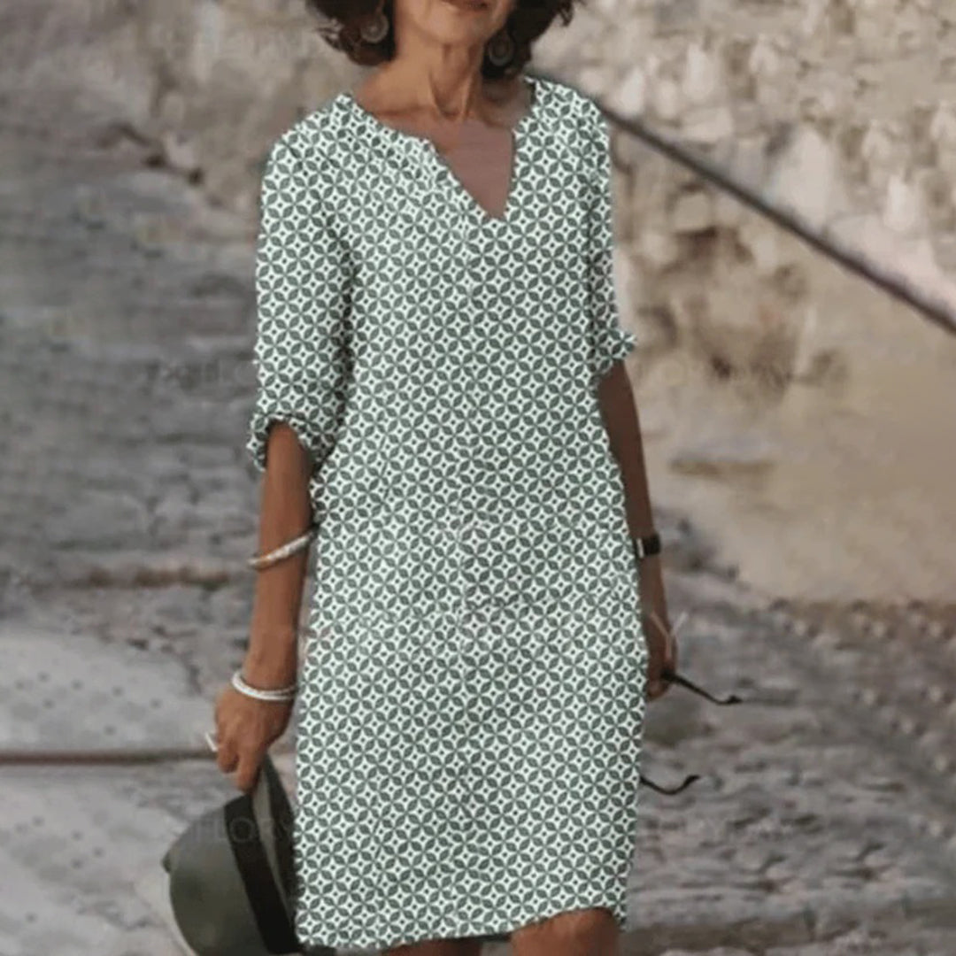 "Zomerjurk NORA: elegant ontwerp, ademende stof, verkrijgbaar in blauw, bruin, grijs, groen. Perfect voor zonnige dagen."