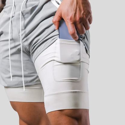 "2-in-1 sportbroek voor heren, blauw, met shorts en geïntegreerde zwarte compressielegging voor comfort en ondersteuning."