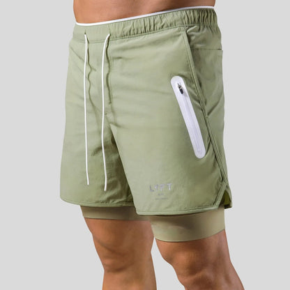 "2-in-1 sportbroek voor heren, blauw, met shorts en geïntegreerde zwarte compressielegging voor comfort en ondersteuning."