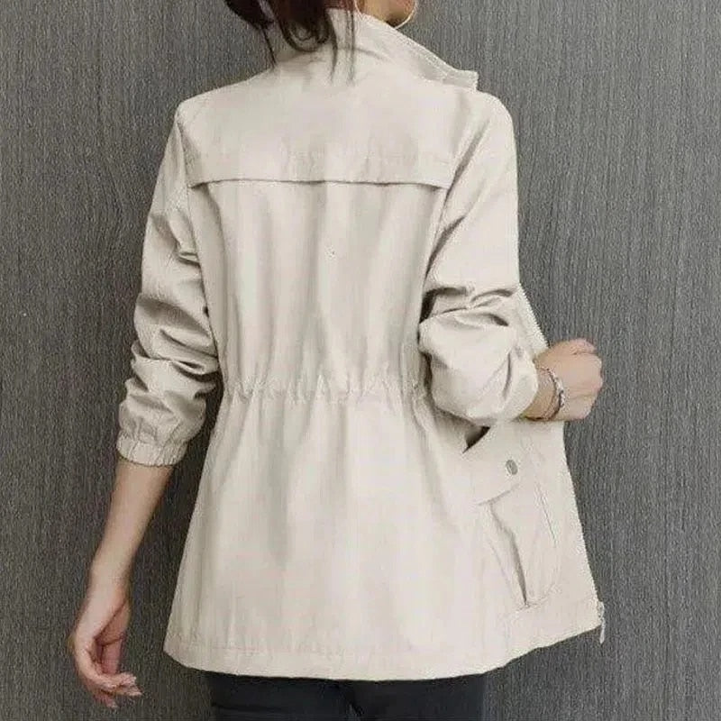 "Dames trenchcoat met verstelbare taille, voorzakken en opstaande kraag, elegante jas in lichte stof, ideaal voor lente."