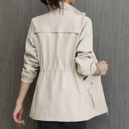 "Dames trenchcoat met verstelbare taille, voorzakken en opstaande kraag, elegante jas in lichte stof, ideaal voor lente."