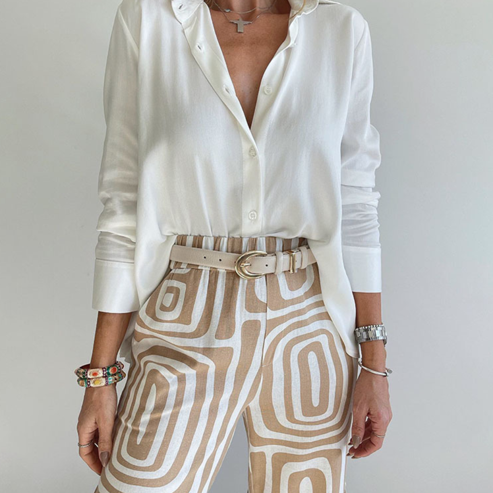 "Damesoutfit met witte blouse en beige printbroek, stijlvolle en trendy mode, elegante casual look voor elke gelegenheid."