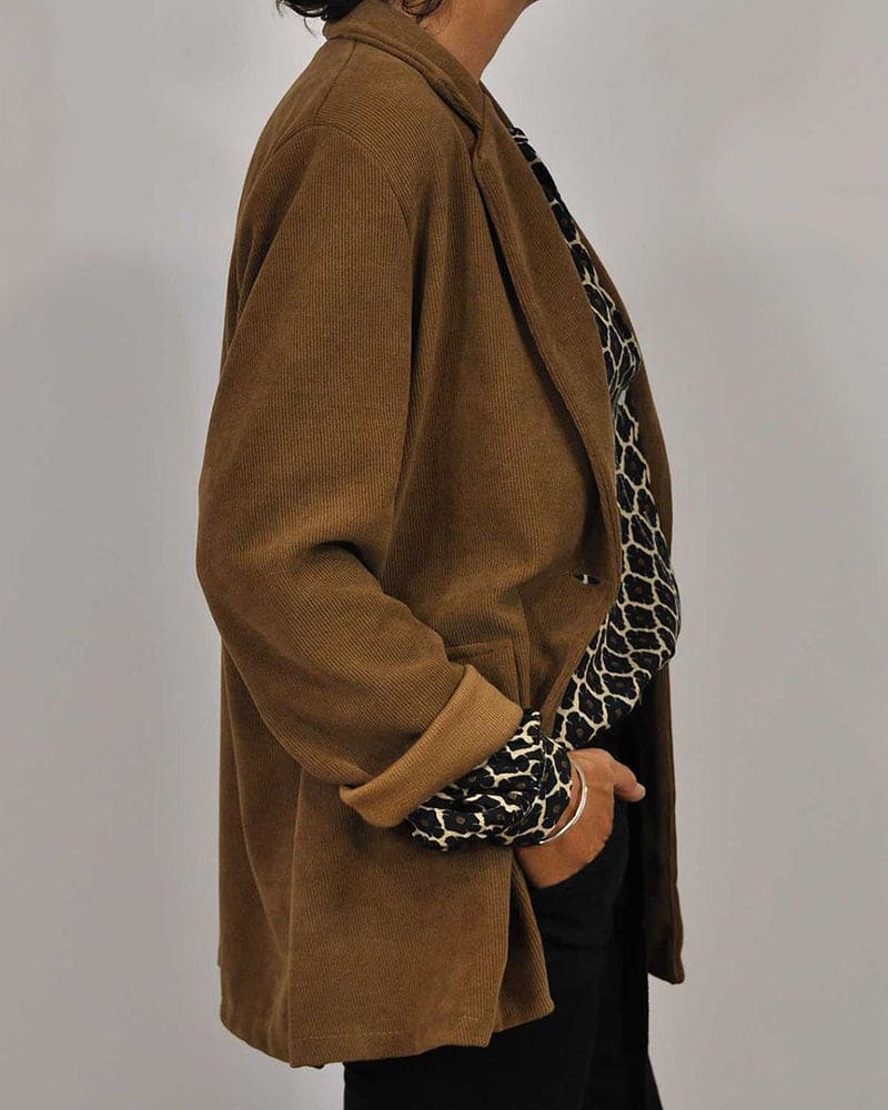 Elegante blouse met V-hals en geometrisch design, subtiele knoopdetails, ideaal voor zowel zakelijke als casual gelegenheden.