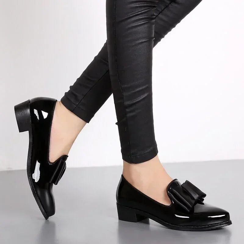 Elegante dames loafers met puntige neus, chique strikdecor en glanzend patent leer, ideaal voor dagelijks comfort.