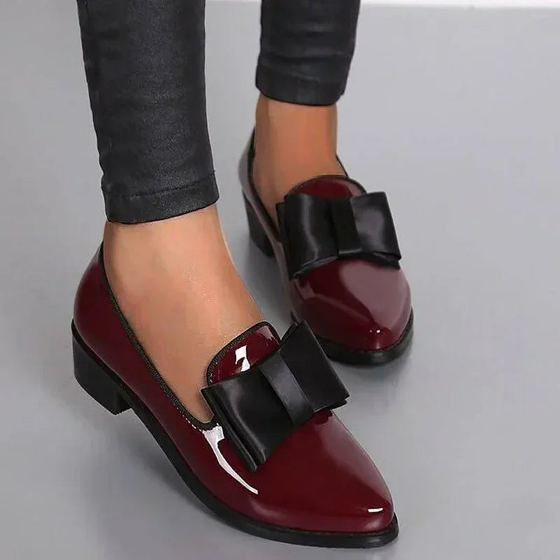 Elegante dames loafers met puntige neus, chique strikdecor en glanzend patent leer, ideaal voor dagelijks comfort.