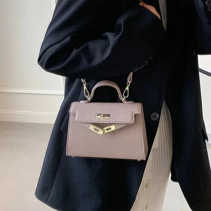 "Elegante dames schoudertas van leer, verkrijgbaar in beige, bruin, wit, en zwart, klassieke en stijlvolle uitstraling."