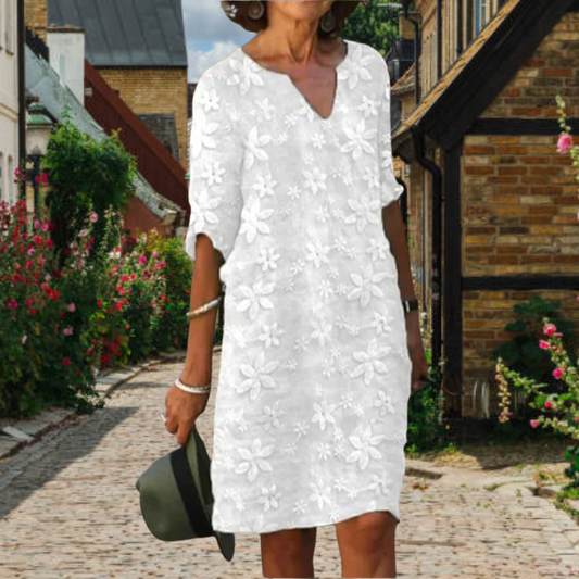 Elegante damesjurk met V-hals en bloemenmotief, verfijnde uitstraling en comfortabele pasvorm, essentieel voor de zomergarder