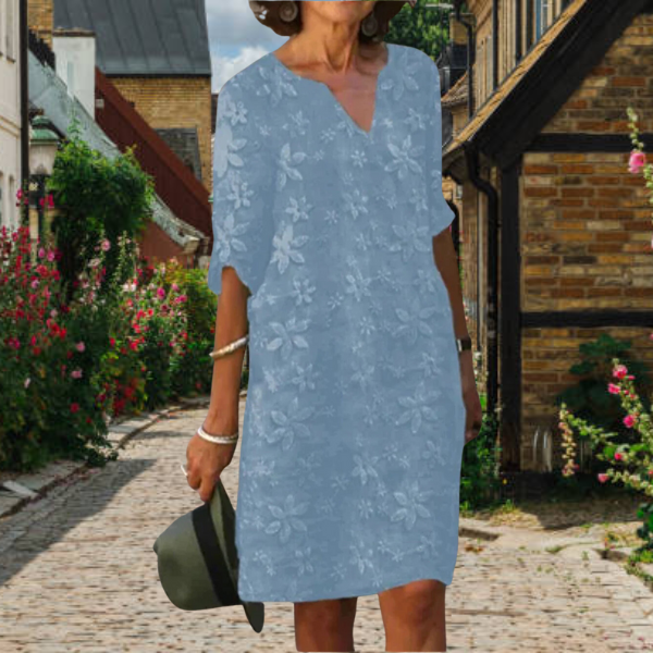 Elegante damesjurk met V-hals en bloemenmotief, verfijnde uitstraling en comfortabele pasvorm, essentieel voor de zomergarder