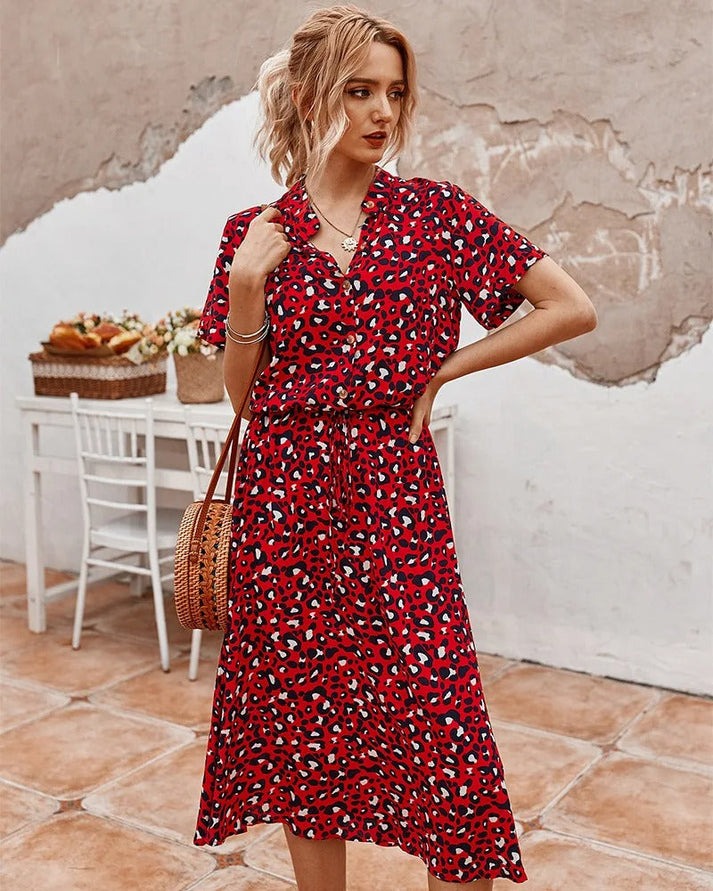 "Elegante Florine midi jurk met strikkoord, luchtige stof, flatterende tailleband en korte mouwen; vrouwelijk ontwerp."