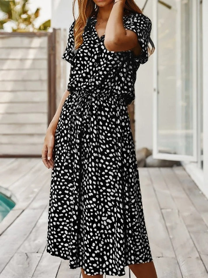 "Elegante Florine midi jurk met strikkoord, luchtige stof, flatterende tailleband en korte mouwen; vrouwelijk ontwerp."