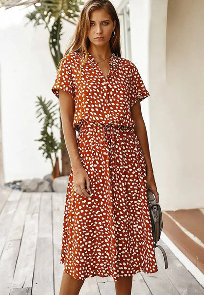 "Elegante Florine midi jurk met strikkoord, luchtige stof, flatterende tailleband en korte mouwen; vrouwelijk ontwerp."