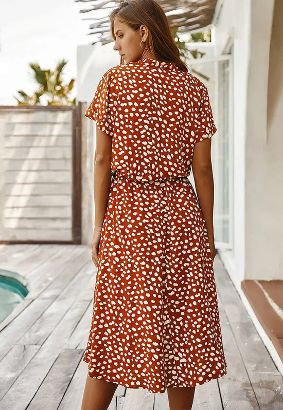 "Elegante Florine midi jurk met strikkoord, luchtige stof, flatterende tailleband en korte mouwen; vrouwelijk ontwerp."