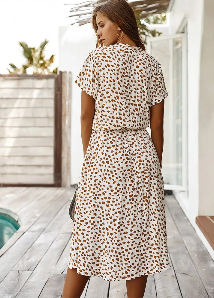 "Elegante Florine midi jurk met strikkoord, luchtige stof, flatterende tailleband en korte mouwen; vrouwelijk ontwerp."