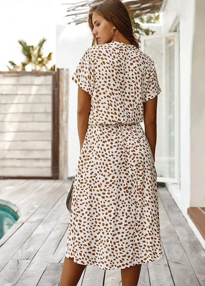 "Elegante Florine midi jurk met strikkoord, luchtige stof, flatterende tailleband en korte mouwen; vrouwelijk ontwerp."
