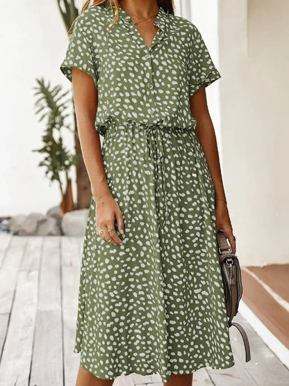 "Elegante Florine midi jurk met strikkoord, luchtige stof, flatterende tailleband en korte mouwen; vrouwelijk ontwerp."