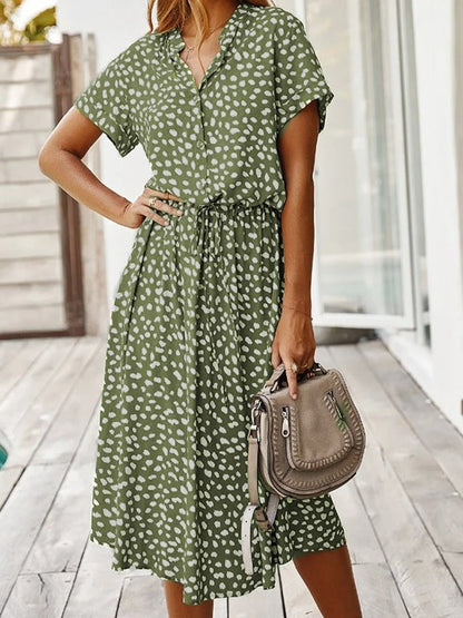 "Elegante Florine midi jurk met strikkoord, luchtige stof, flatterende tailleband en korte mouwen; vrouwelijk ontwerp."