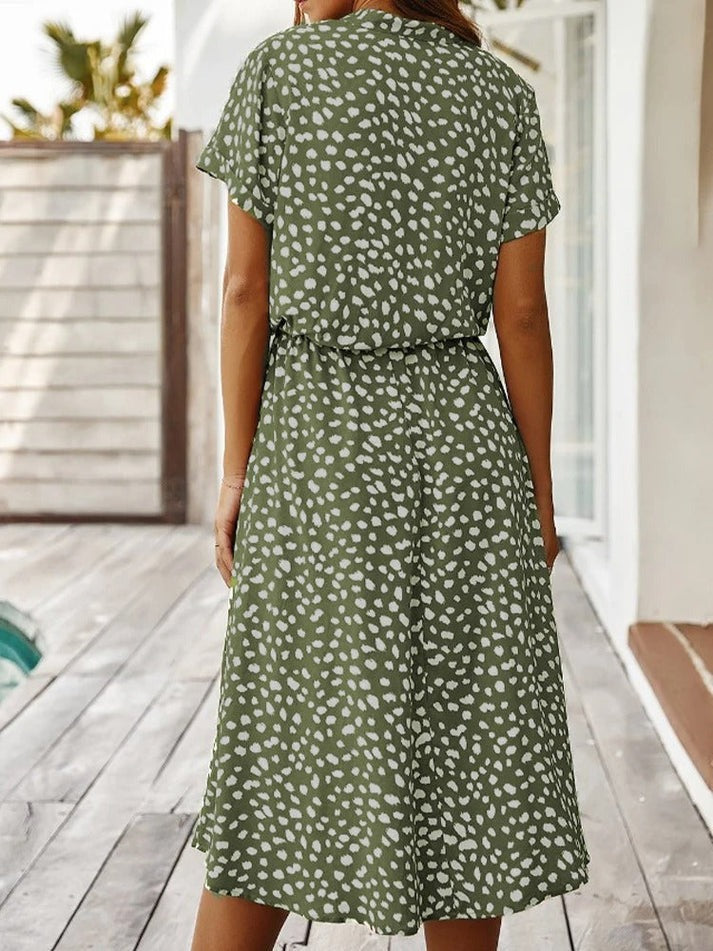 "Elegante Florine midi jurk met strikkoord, luchtige stof, flatterende tailleband en korte mouwen; vrouwelijk ontwerp."