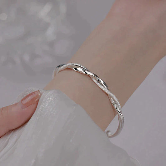 "Elegante gedraaide zilveren armband voor dames, verstelbaar, met glanzende afwerking en modern ontwerp"