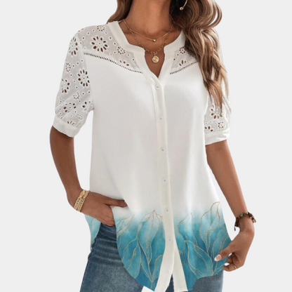 "Elegante lichtblauwe damestop met korte mouwen, kanten details en losse pasvorm voor een stijlvolle en comfortabele look."