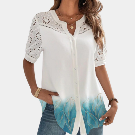 "Elegante lichtblauwe damestop met korte mouwen, kanten details en losse pasvorm voor een stijlvolle en comfortabele look."