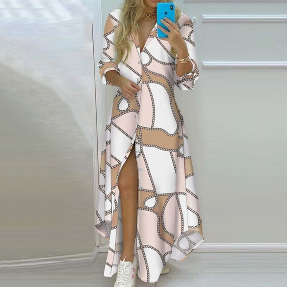 "Elegante maxi Antonia zomerjurk met artistieke kranten print, perfecte pasvorm voor trendy zomerse look."
