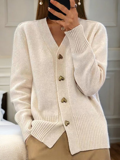 Elegante witte dames cardigan met gouden hartvormige knopen en ribgebreide boorden voor comfort en stijl.