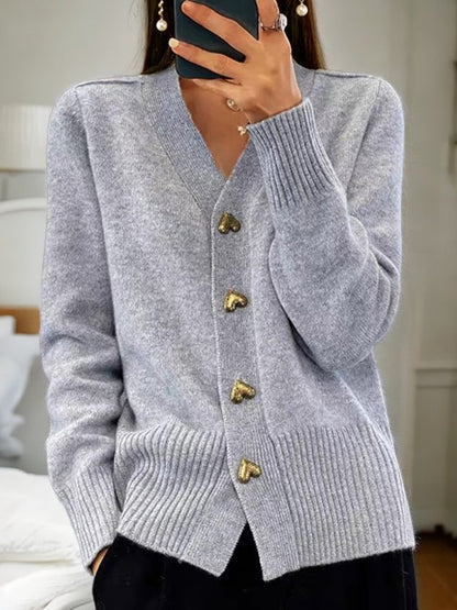 Elegante witte dames cardigan met gouden hartvormige knopen en ribgebreide boorden voor comfort en stijl.