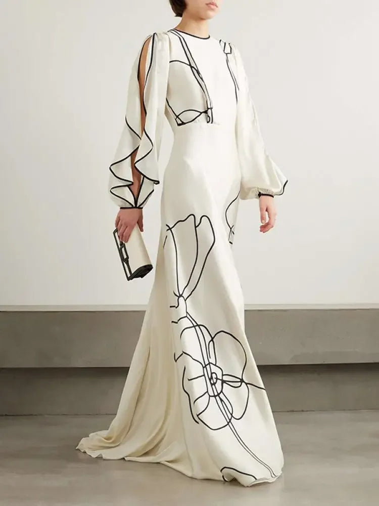 "Eline avondjurk met bloemenprint, gerimpelde mouwen en Falbala-details in witte en zwarte tinten, elegant ontwerp."