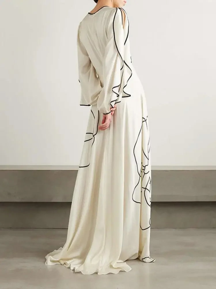 "Eline avondjurk met bloemenprint, gerimpelde mouwen en Falbala-details in witte en zwarte tinten, elegant ontwerp."