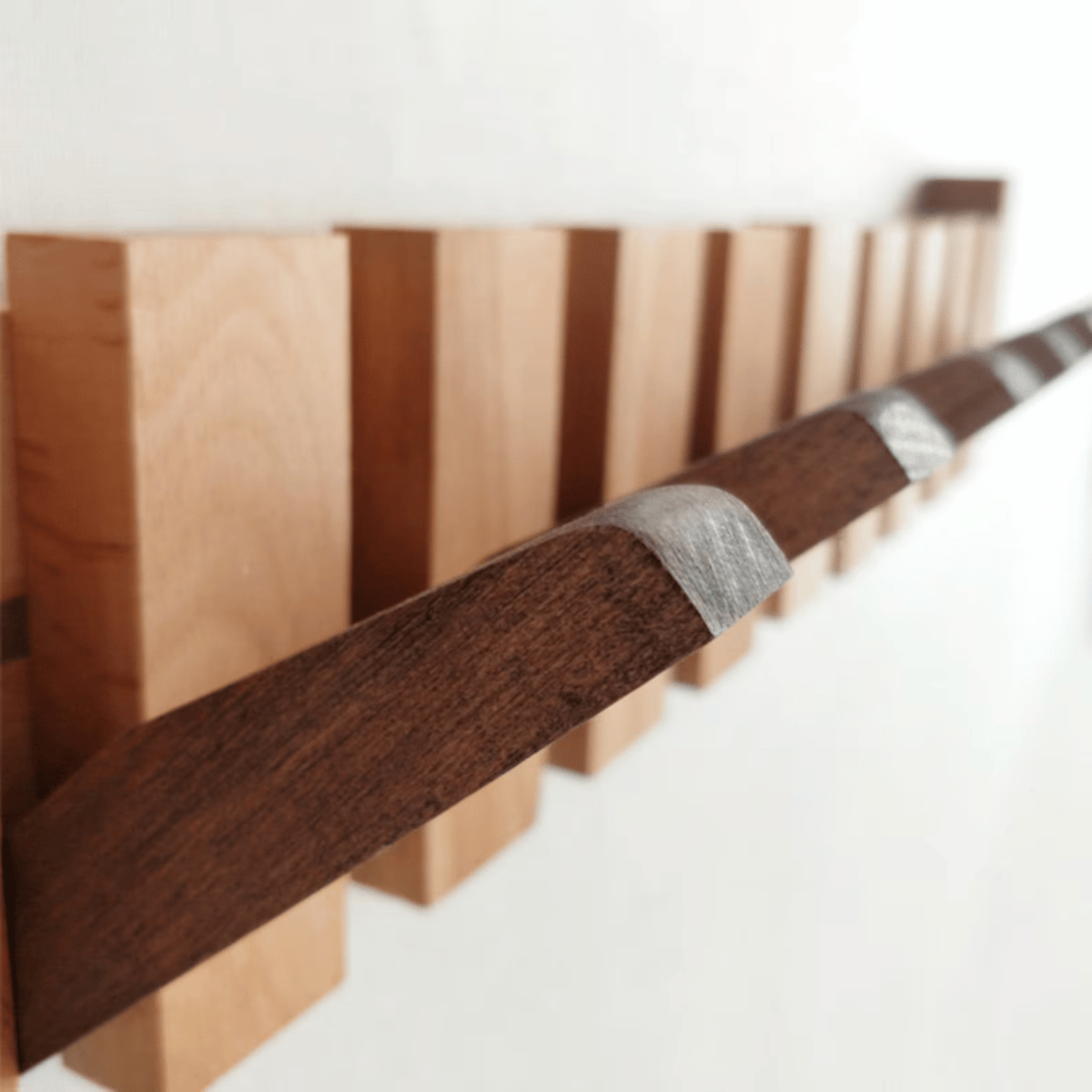 Handgemaakte houten kapstok in piano design met elegante, pianotoetsen uitstraling. Perfect voor stijlvolle jassenopslag.