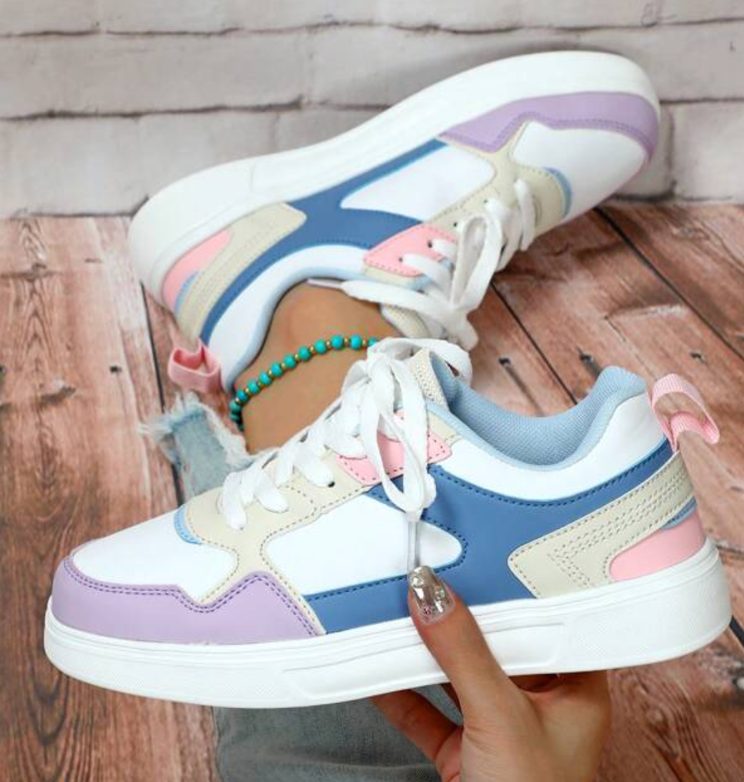 "Kleurrijke dames sneakers met wit, blauw, zwart en roze design, ademend materiaal en ergonomische pasvorm voor comfort."